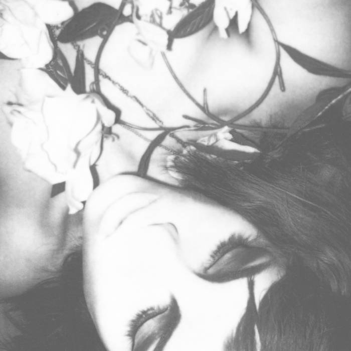 Monochrome picture of a young womans head and white flowers, overexposed.